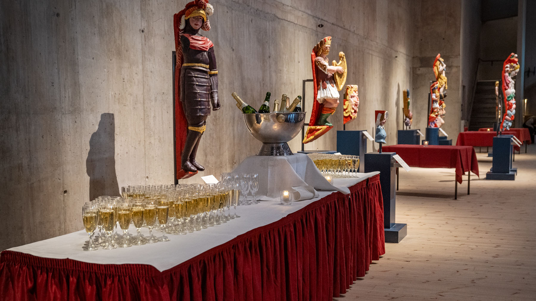 Dukat bord med vinglas syns i museimiljö.