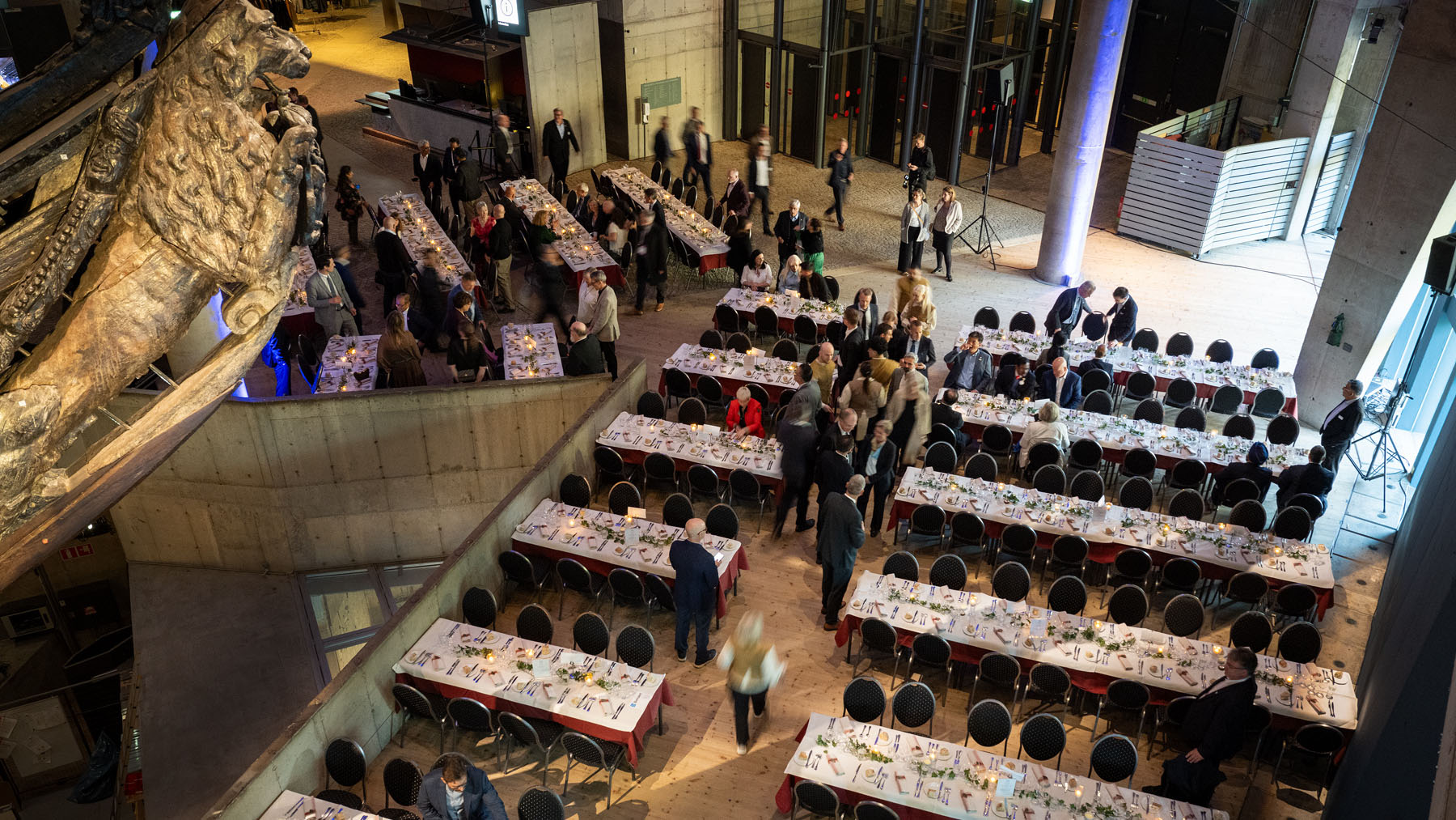 Vasamuseets skeppshall sett från övervåningen, ett galjonslejon syns över dukade bord och middagsgäster. 