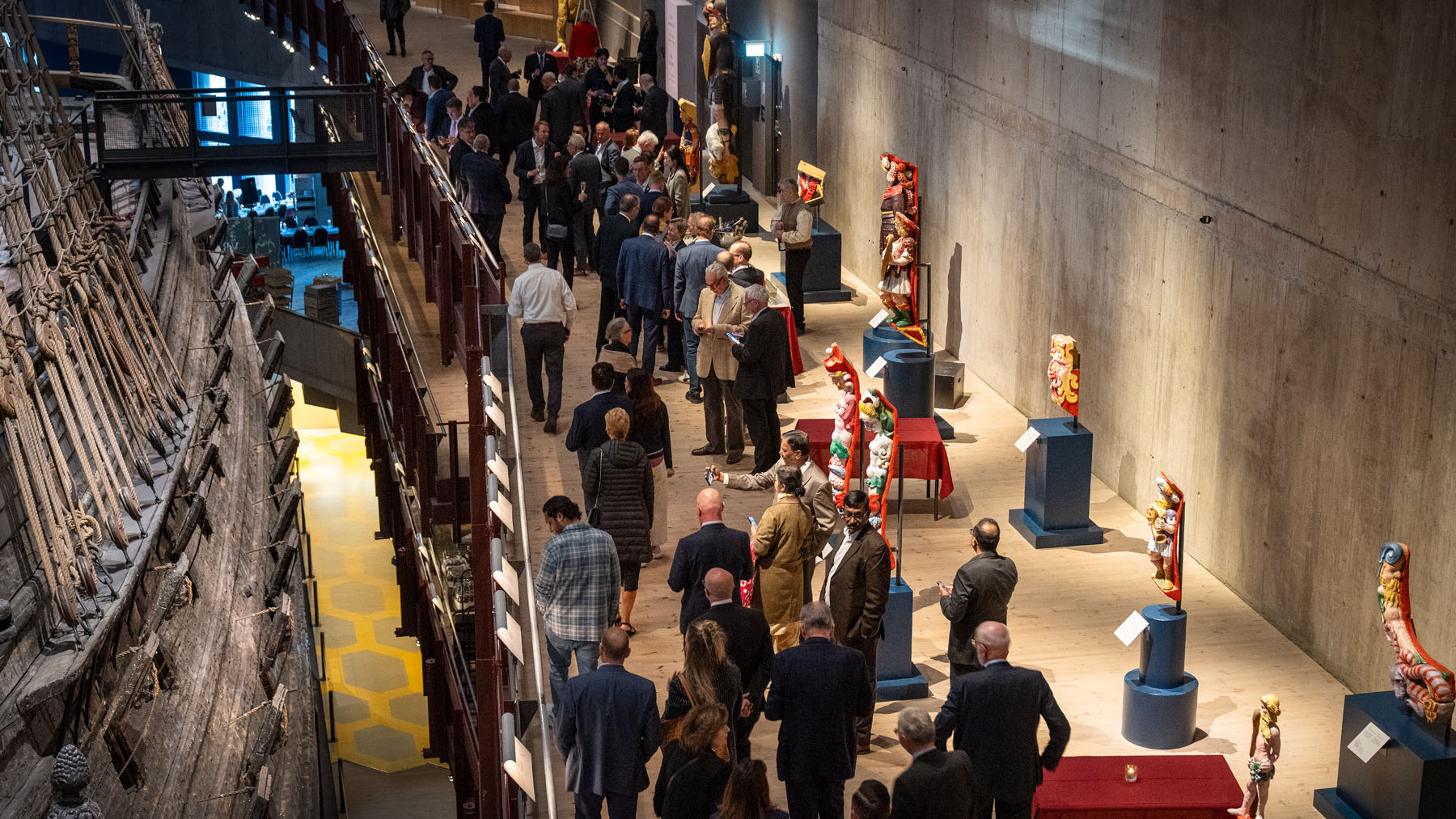 Sidan av skeppet Vasa och besökare på våningen intill. 