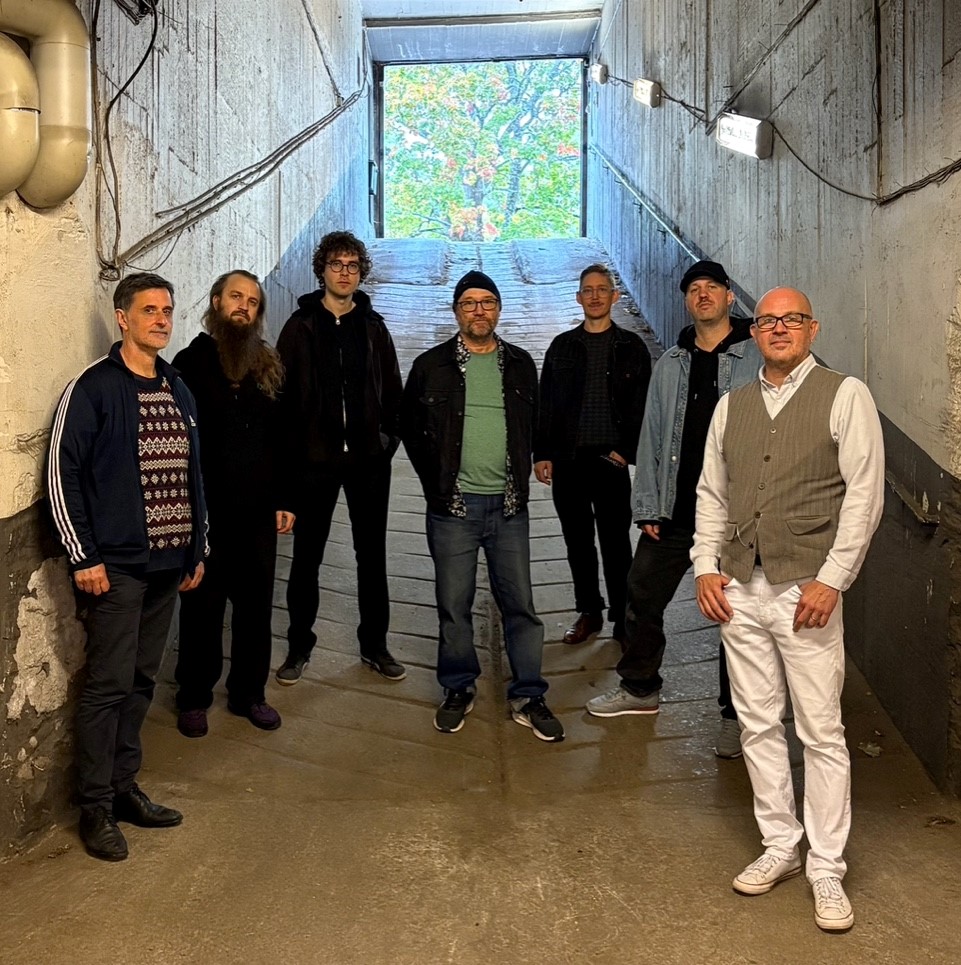 De sjumedlemmarna i Seven Piece Machine ståruppradade i ett garage