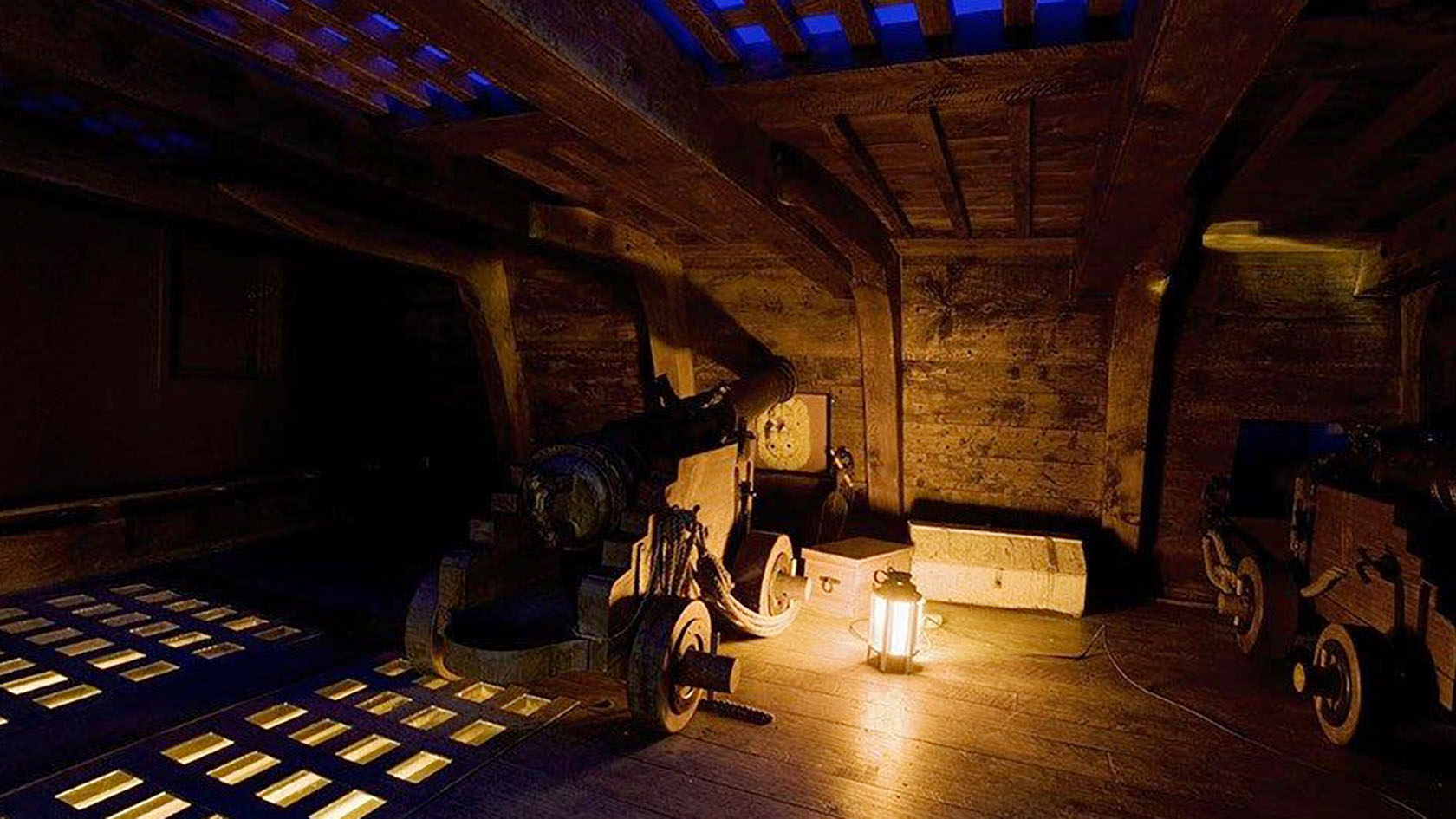 Foto av modell av Vasas kanondäck, som visar kanon, kanonluckor och en lykta. 