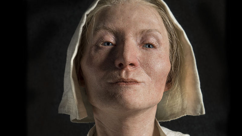 Foto av modell av blond kvinna i vit mössa mot svart bakgrund