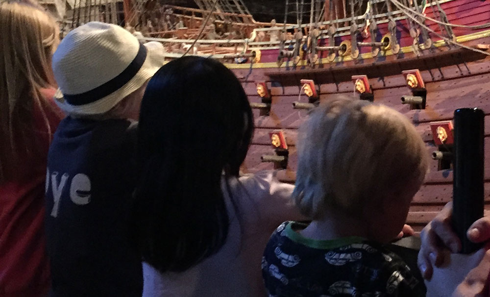 Fyra barn tittar på modellen av Vasa som finns utställd i museet.