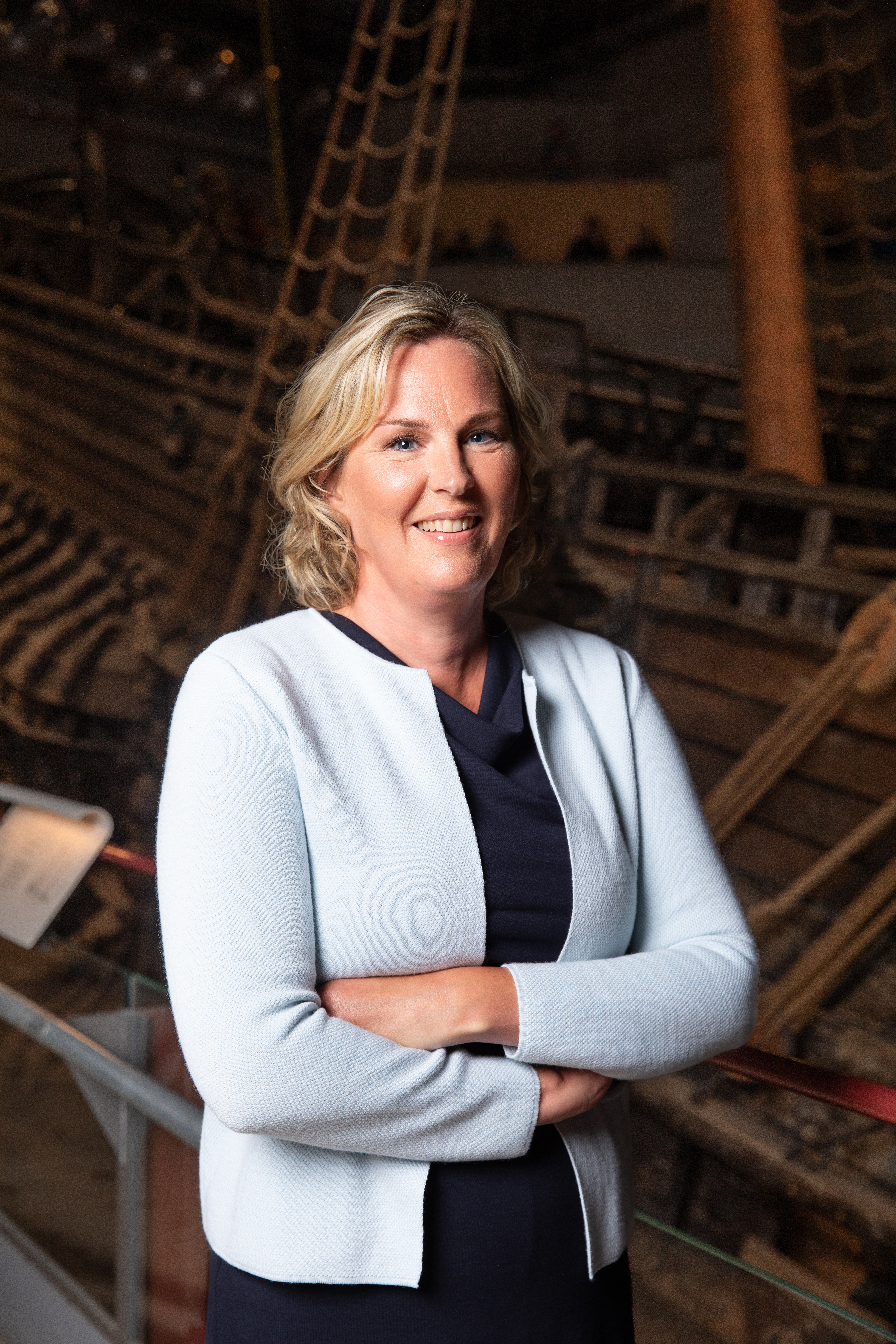 Foto av leende, blond kvinna framför skeppet Vasa.