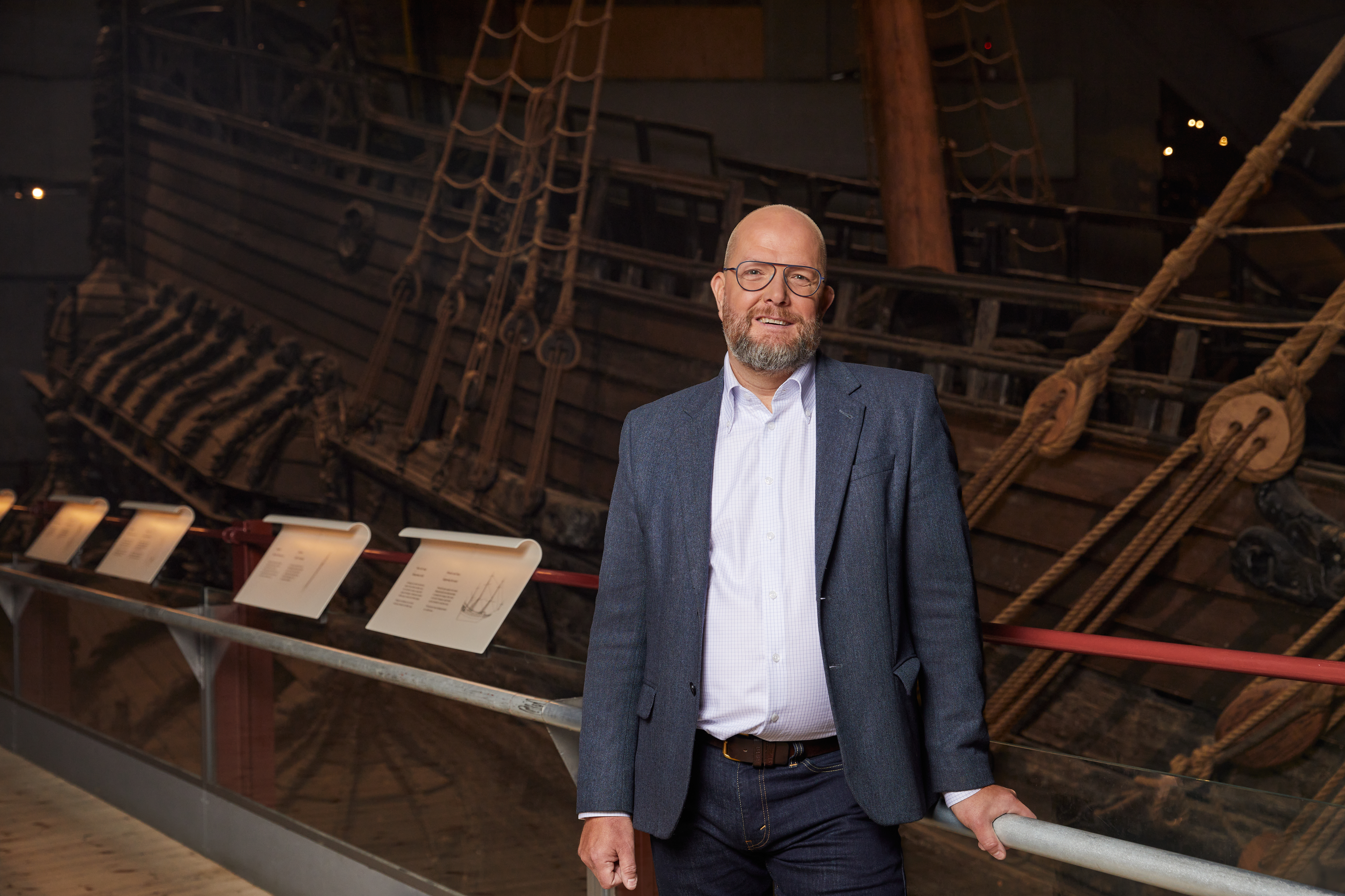 Man i grå kavaj vid skeppet Vasa